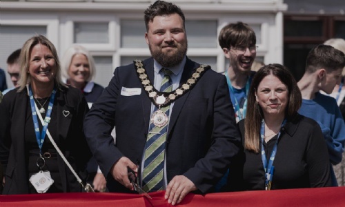 Mayor cutting a red ribbon